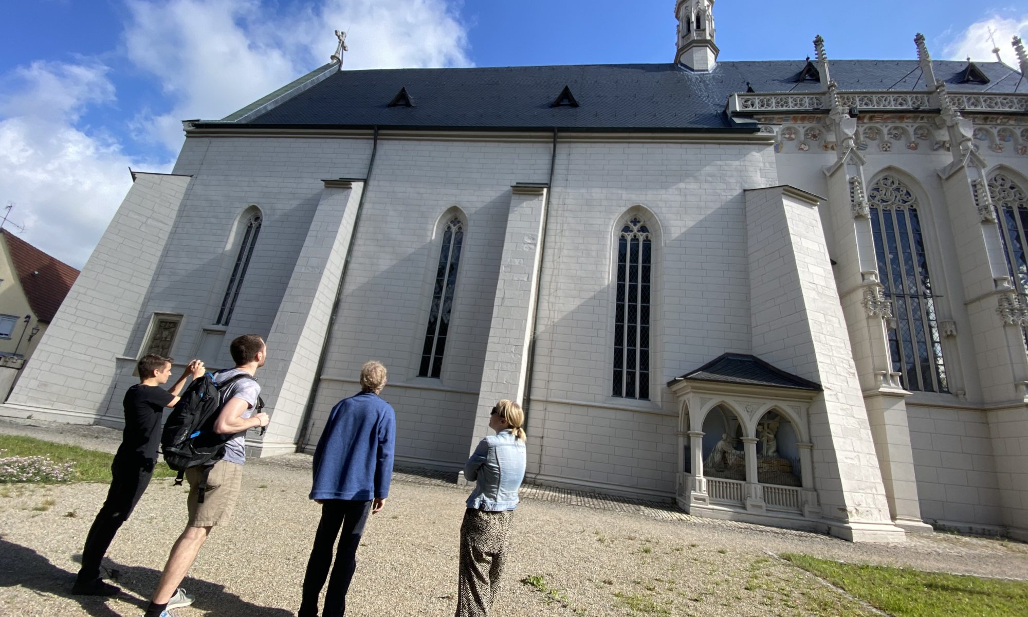 Bild einer weißen Kapelle mit Menschen davor