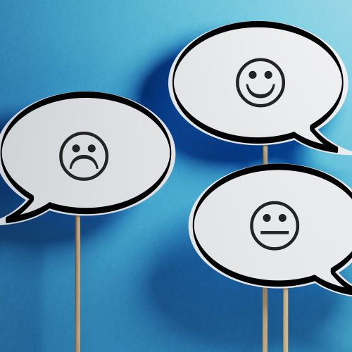 drei weiße Sprechblasen mit verschiedenen Smileys vor einem blauen Hintergrund 