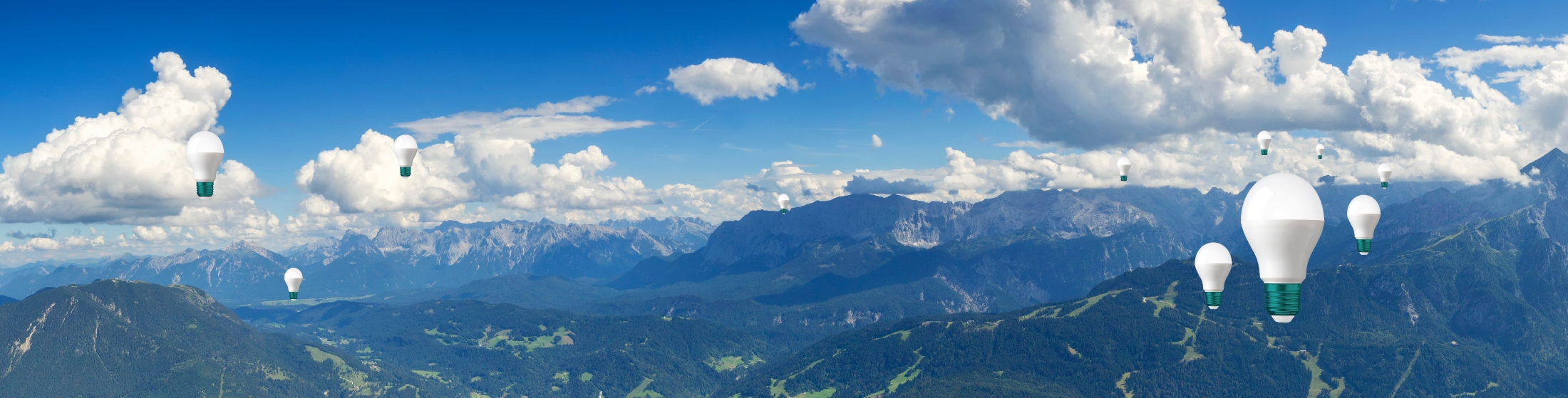 Glühbirnen schweben über einem Gebirge