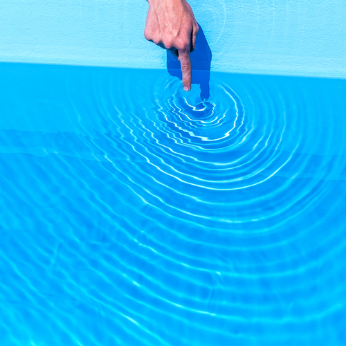 Finger der Wasser berührt