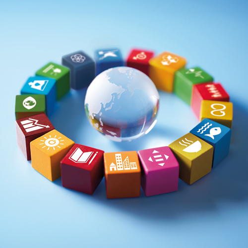 Ein Globus umgeben von bunten Würfeln, die Vielfalt und globale Vernetzung symbolisieren.