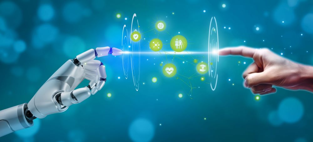 Das Bild zeigt eine symbolträchtige Szene, in der sich eine menschliche Hand und eine Roboterhand beinahe berühren – eine Anspielung auf die Verbindung zwischen Mensch und Technologie. Zwischen den Fingerspitzen der beiden Hände verläuft ein leuchtender Lichtstrahl, der als zentrales Element die Interaktion hervorhebt.