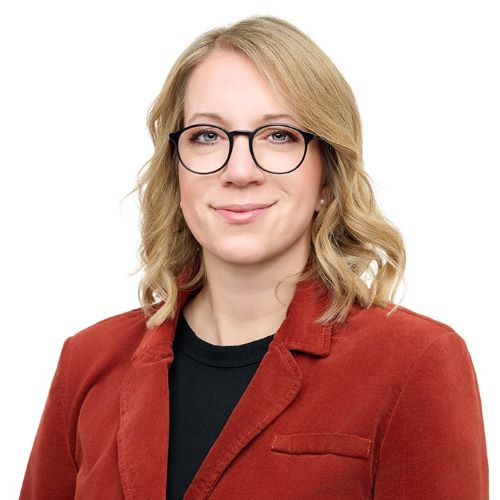 Auf dem Bild ist eine Frau mit blonden Haaren und schwarzer Brille zu sehen