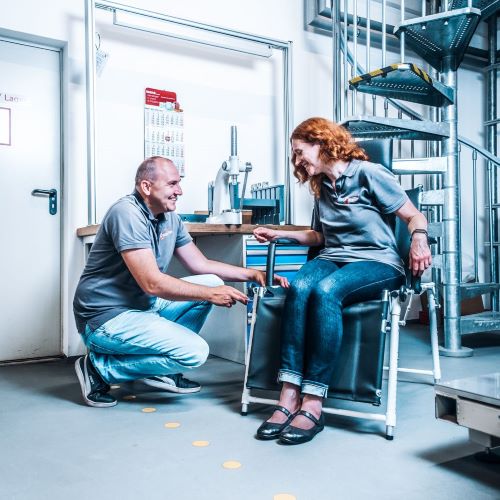 Ein Mann und eine Frau sitzen auf einem Stuhl in einem Lagerhaus.