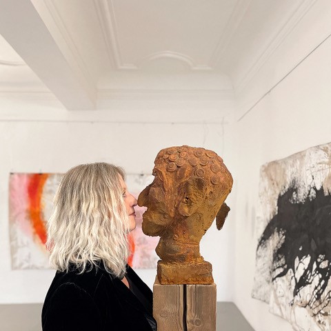 Martina Leithenmayr vor einer Holzskulptur