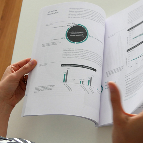 Eine Person hält ein Buch mit einem Diagramm auf der Seite.