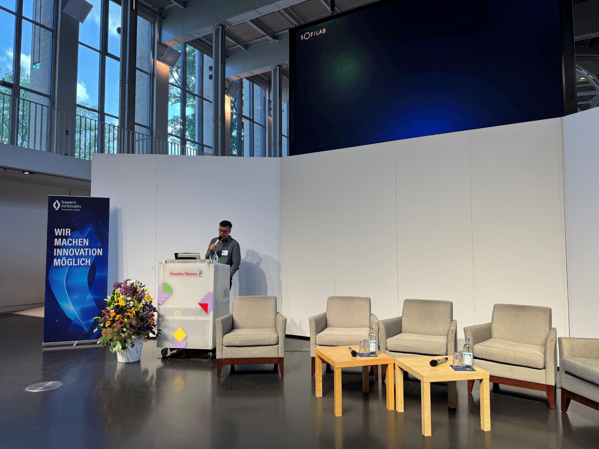 The Sound of Robotics – Sonic Interaction Design als Schnittstelle zwischen Mensch und Ma-schine: Mathis Nitschke, Komponist, Technologe und Unternehmer bei der Sofilab GmbH in München, spricht in ein Mikrofon am Pult.