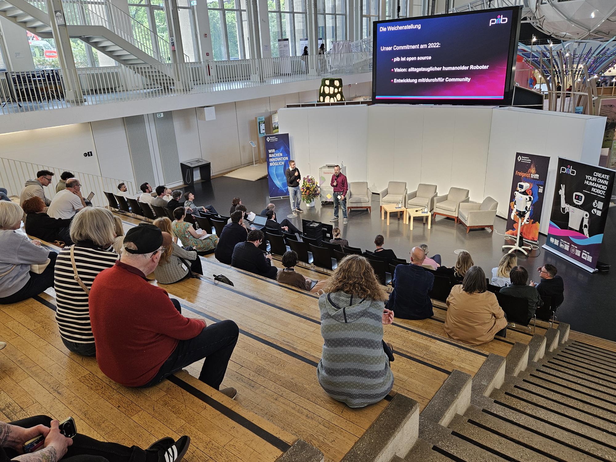 Die unerwarteten Aha-Momente: Was passiert, wenn Kreative ins Spiel kommen: TJ Graebe, Problemlöser, isento GmbH und Dr. Jürgen Baier, Geschäftsführer, isento GmbH, sprechen vorne auf der Bühne zum Publikum.