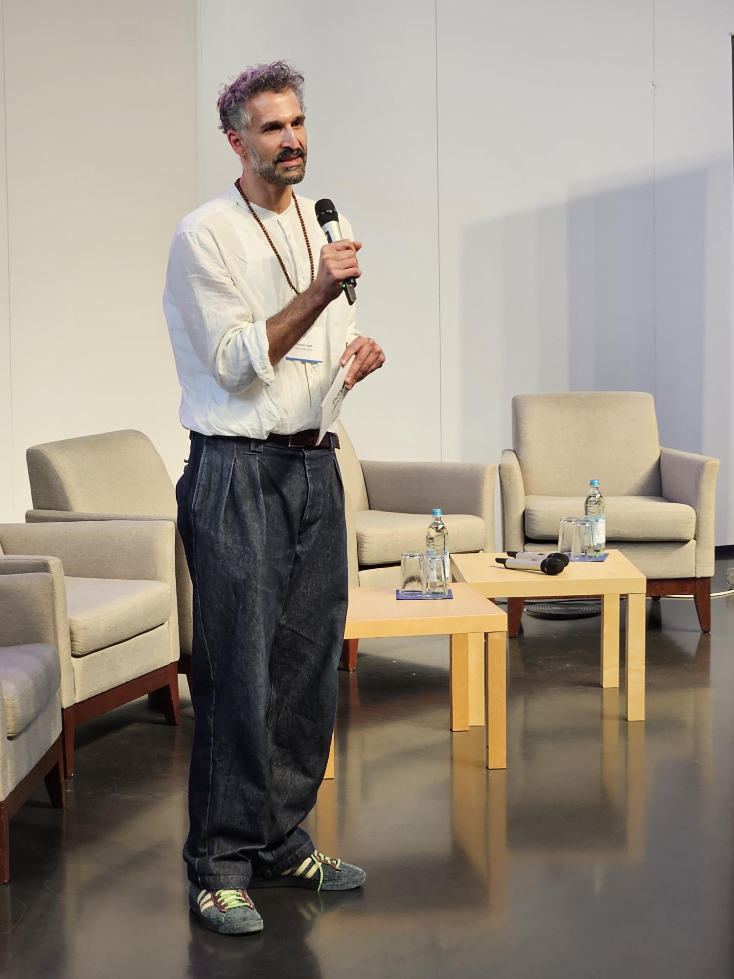 Christian Fayek, Leitung Projekte, bayern design GmbH, spricht in ein Mikrofon.