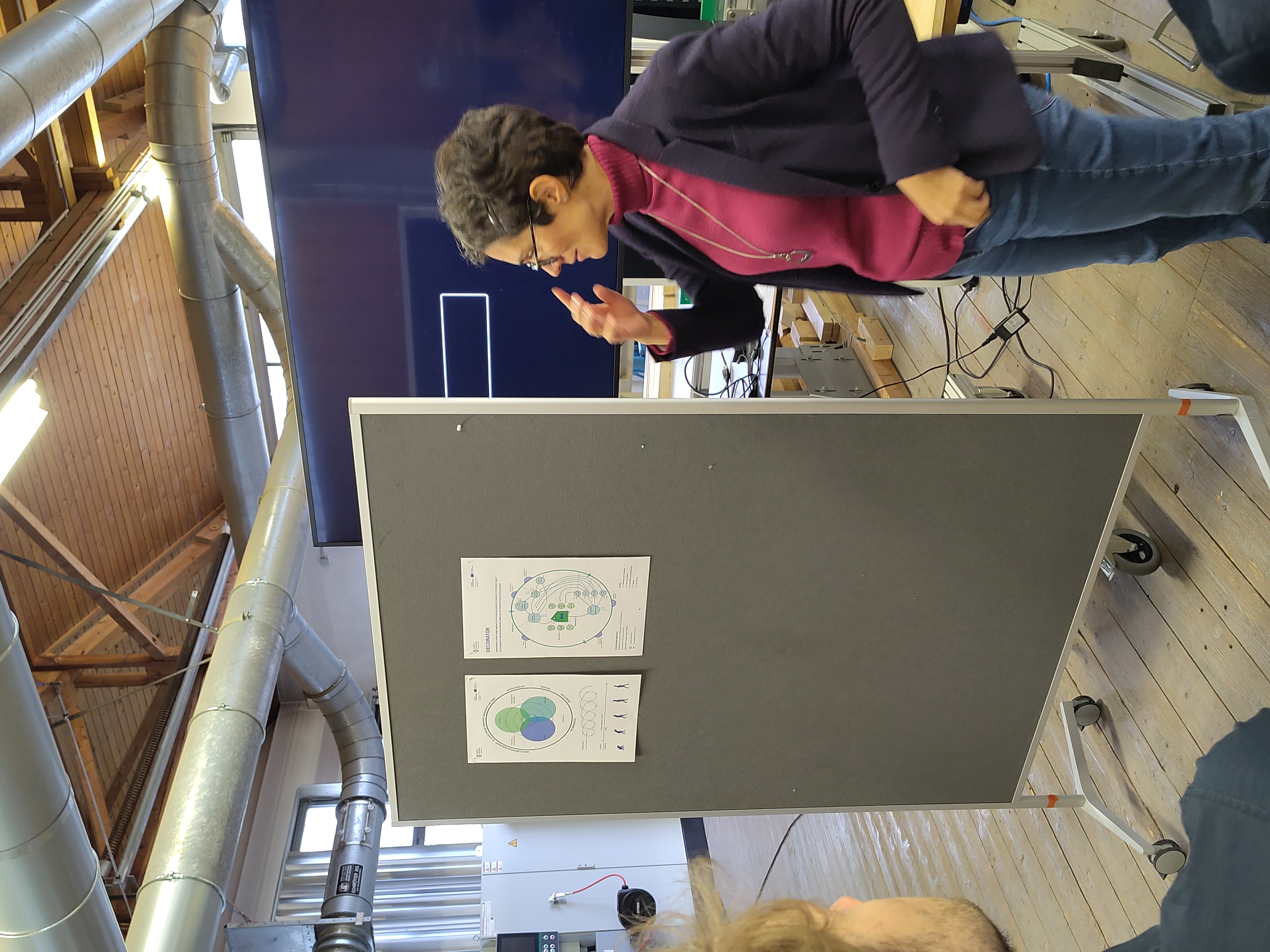 Referentin vor einer Pinnwand mit zwei Postern. 