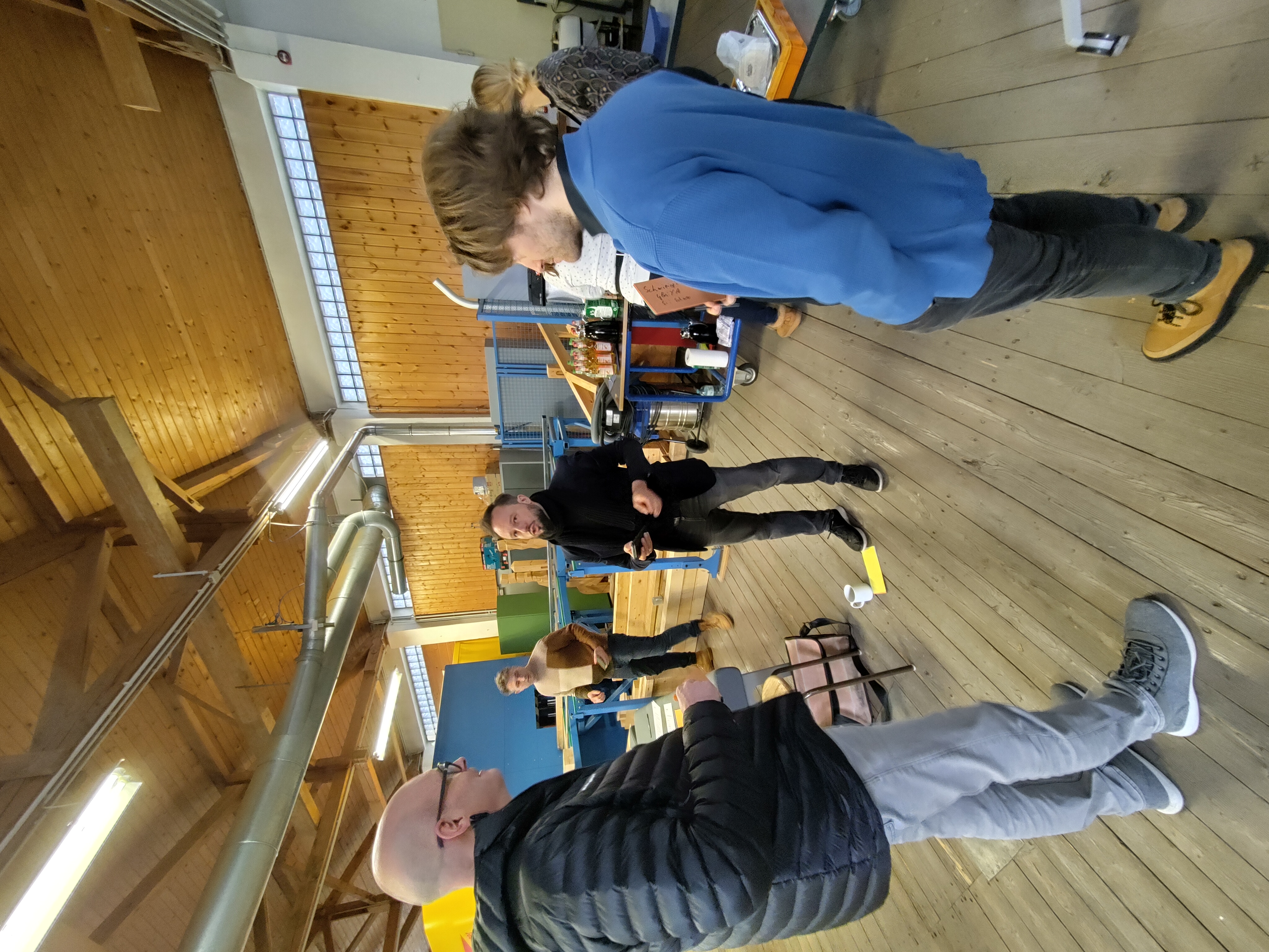 Gruppe von Menschen versammelt in einem Labor-Sägewerk. 