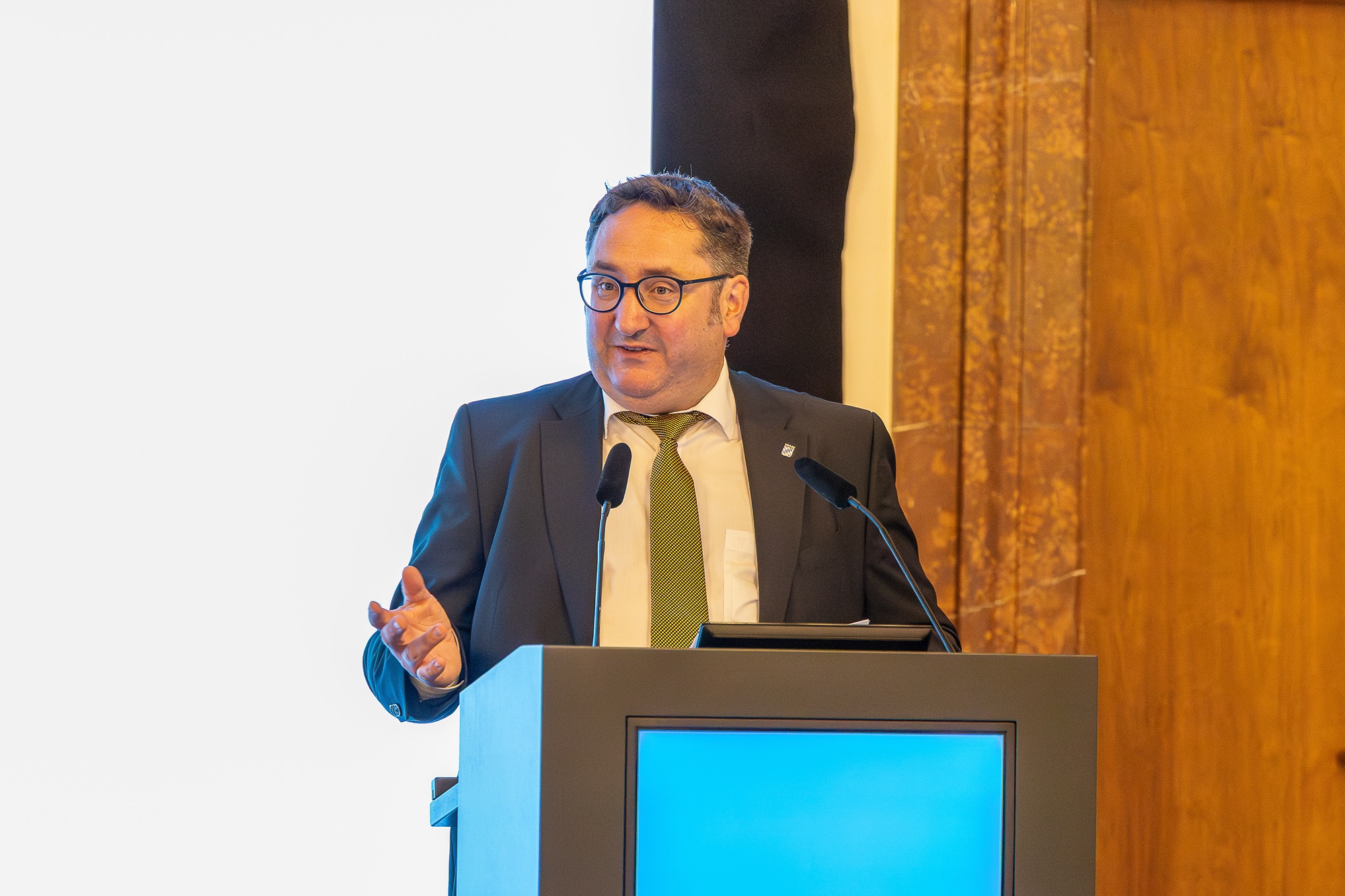 Tobias Gotthardt, Staatssekretär im Bayerischen Staatsministerium für Wirtschaft, Landesentwicklung und Energie, spricht an einem Rednerpult.