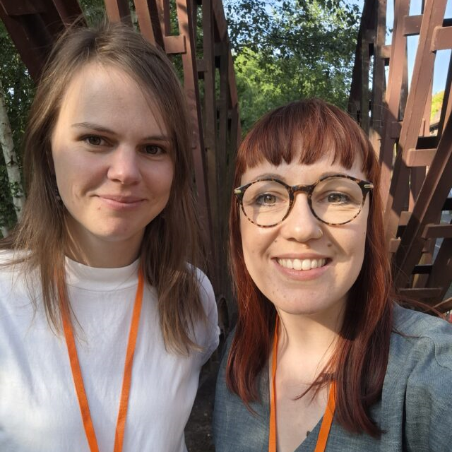 Es sind zwei weibliche Personen zu sehen, die das Green Culture Festival besuchten. Sie lächeln aufgeschlossen und freundlich. Eine Person trägt eine Brille. 