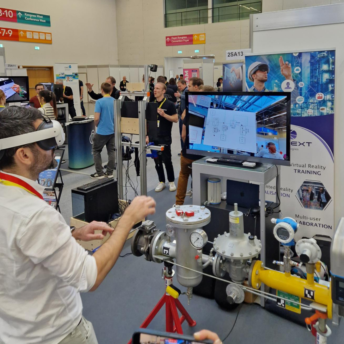 Ein Besucher an einem Messestand testet ein Programm mit VR Steuerung.