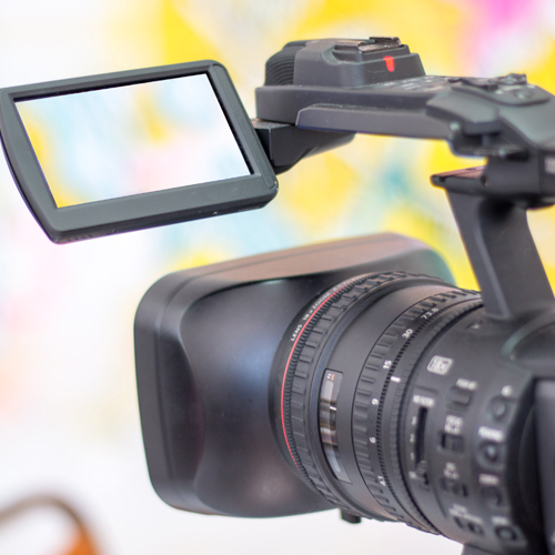 Ein Camcorder, im Hintergrund farbige Flächen
