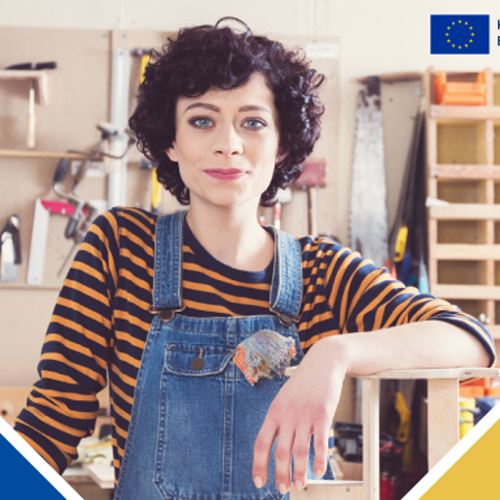 Eine Frau in Latzhose steht an einem Regal.