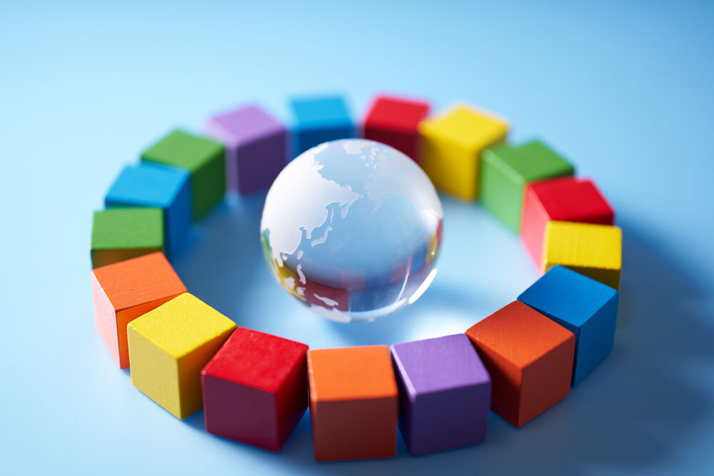 Kreis aus verschiedenfarbigen Bausteinen mit einer Weltkugel aus Glas in der Mitte