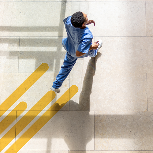 Blick von oben auf einen Mann, der über einen Platz läuft.