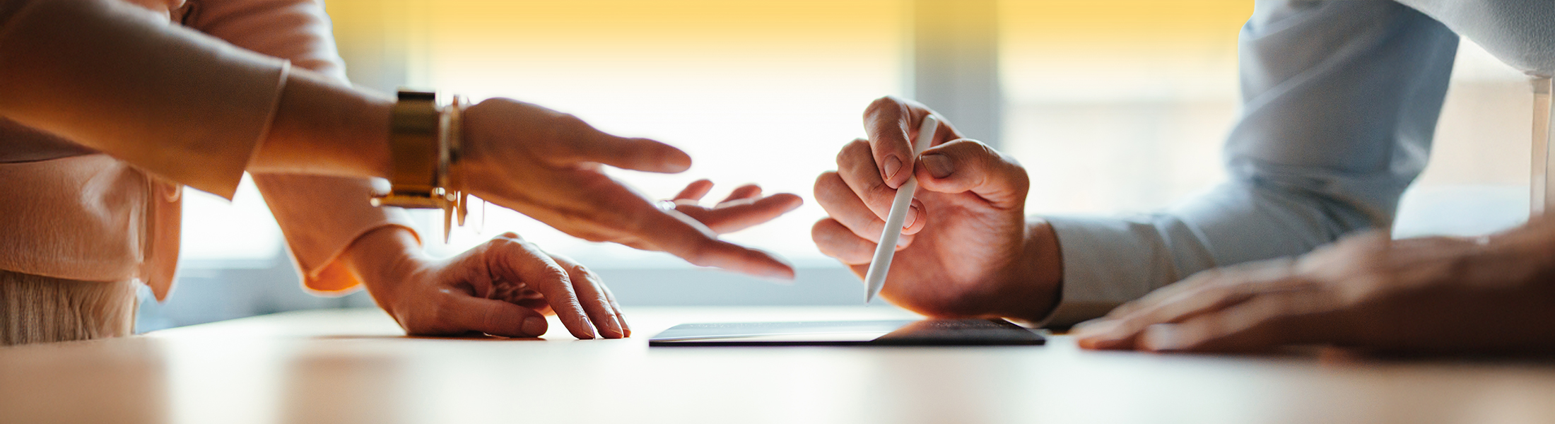 Zwei Menschen schauen auf ein Tablet und diskutieren.