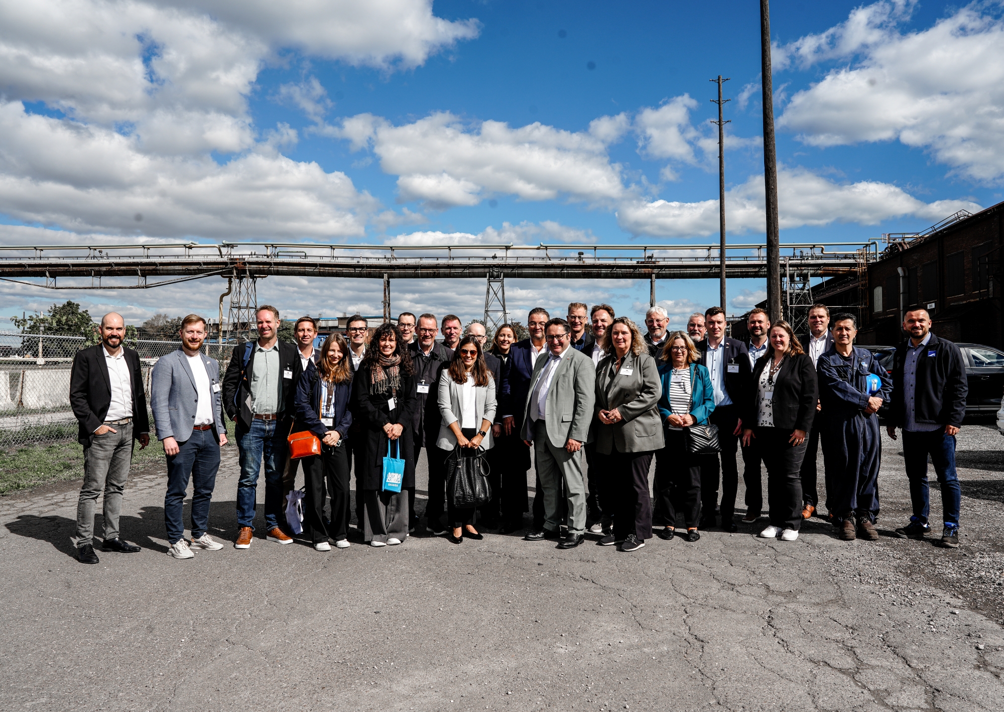 Gruppenfoto im Freien mit zahlreichen Teilnehmenden vor einem Fluss und weitem Himmel – sonniges Wetter. Entstanden im Rahmen der Delegationsreise in Kanada.