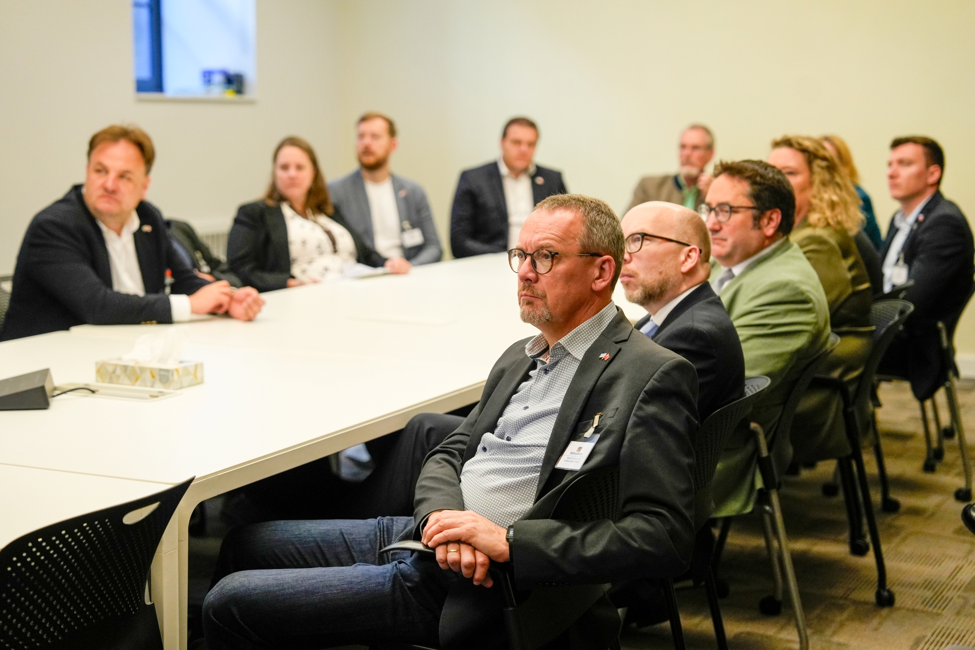 Personen sitzen in einem Konferenzraum an einem Tisch, hören einer Präsentation oder Diskussion zu. Die Szene stammt von einem Termin der Delegationsreise in Kanada.