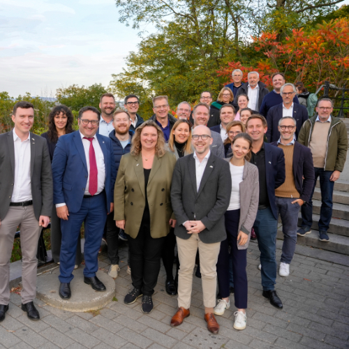 Gruppenfoto im Freien mit Herbstbäumen im Hintergrund, mehrere Teilnehmende in formeller Kleidung. Aufgenommen bei der Delegationsreise in Kanada.