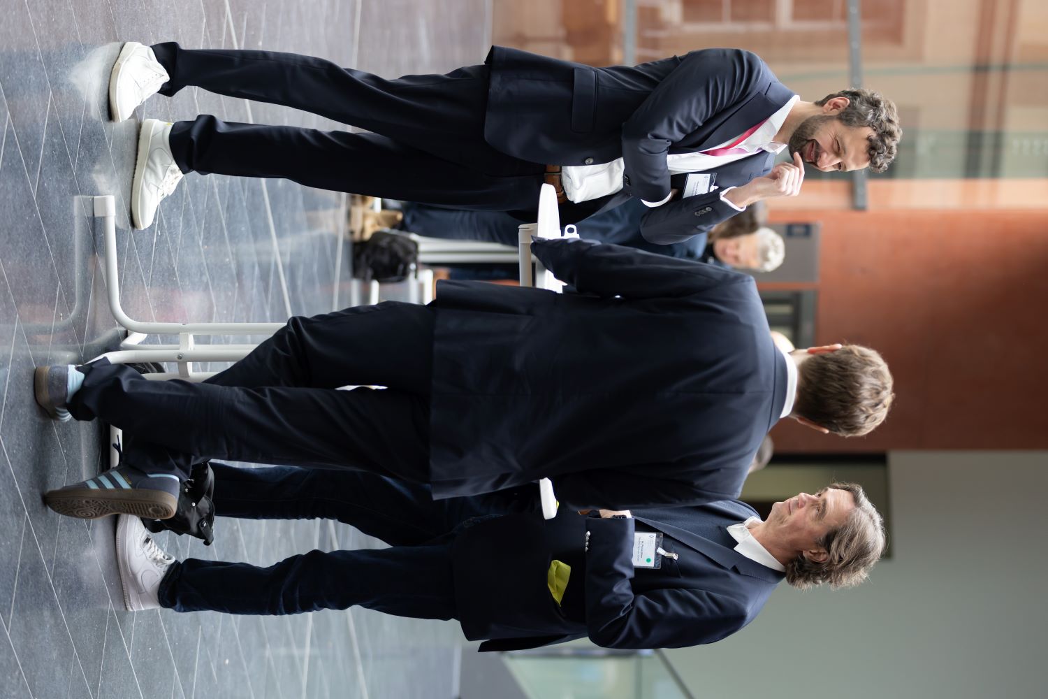 Mehrere Männer stehen um einen Tisch und diskutieren.