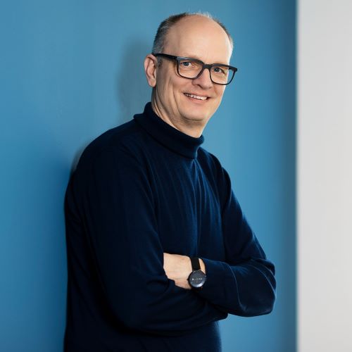 Profile picture of Dr. Tim Hentschel in front of a blue wall.