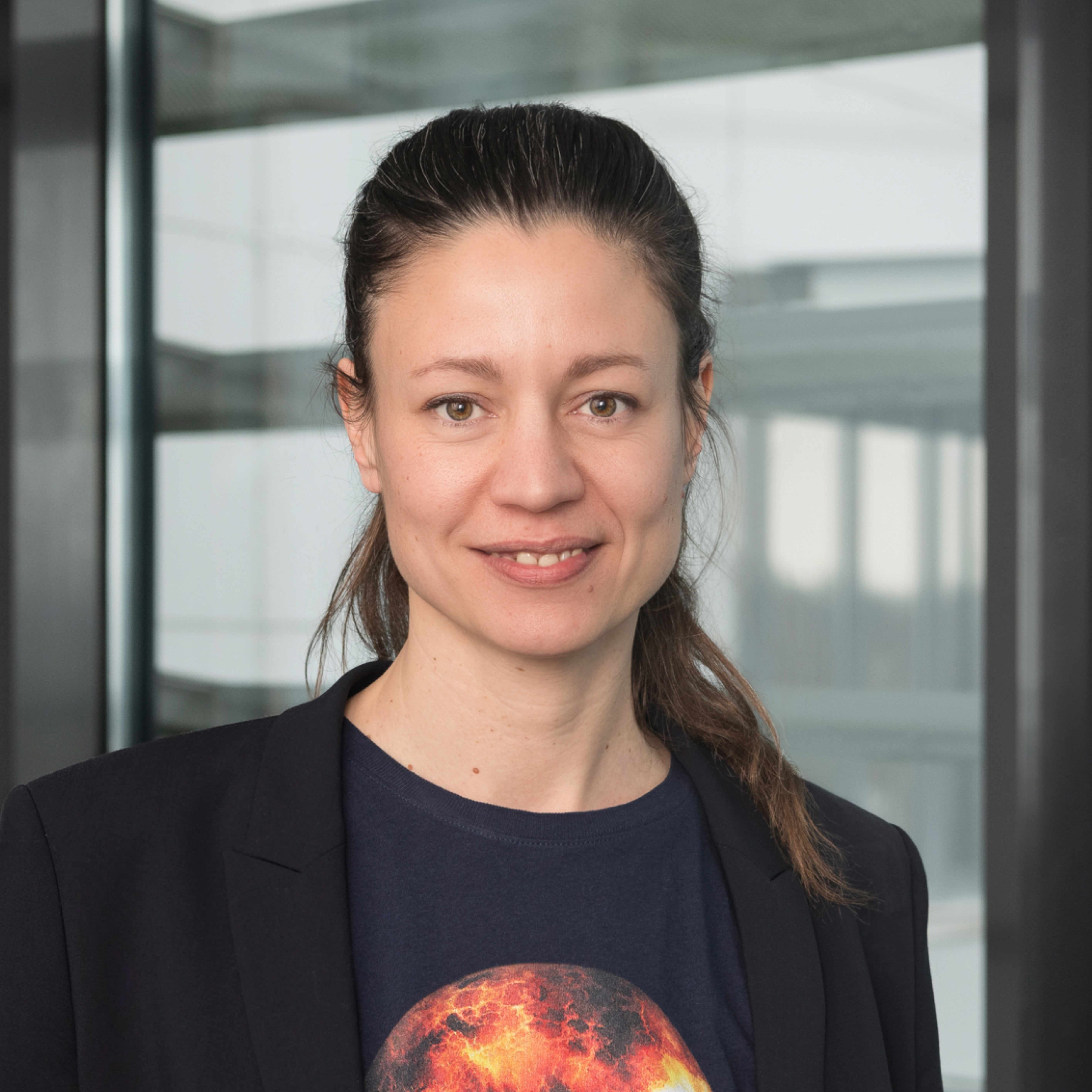 Portraitbild von Sabine von der Recke, eine Frau mit dunkelbraunen Haaren, die in einem Zopf nach hinten gebunden sind. Sie trägt ein dunkelblaues T-Shit mit einem schwarzen Blazer darüber.