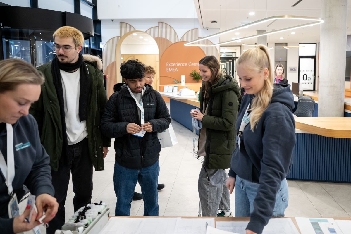 Frauen und Männer stehen an einem Check in Schalter in einem Eingangsbrereich