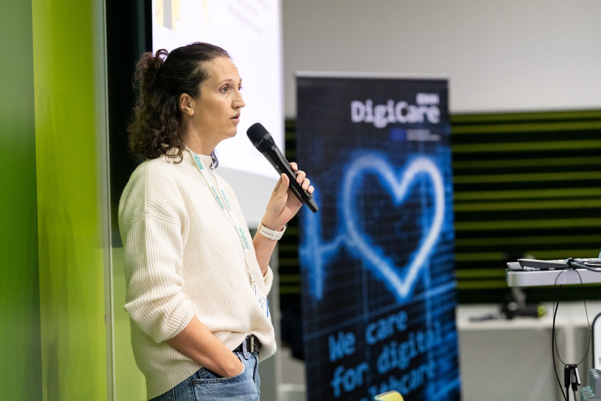 Eine Frau hält einen Vortrag, sie trägt eine weiße Bliuse