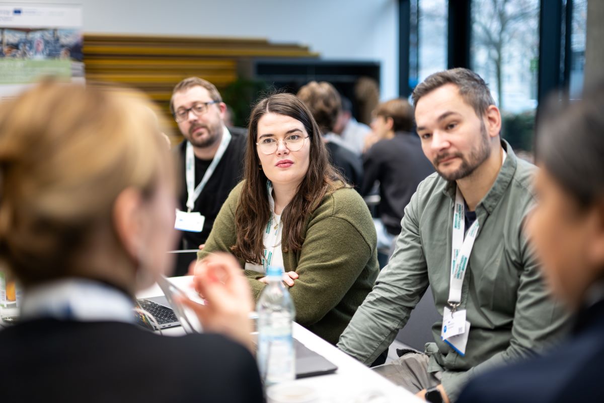 eine Gruppe Menschen sitzen an einem Tisch und unterhalten sich