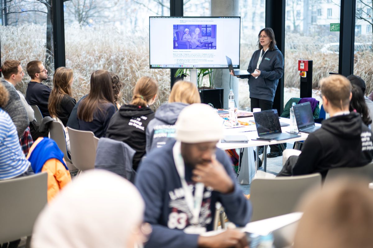 Menschen sitzen an Tischen und arbeiten zusammen