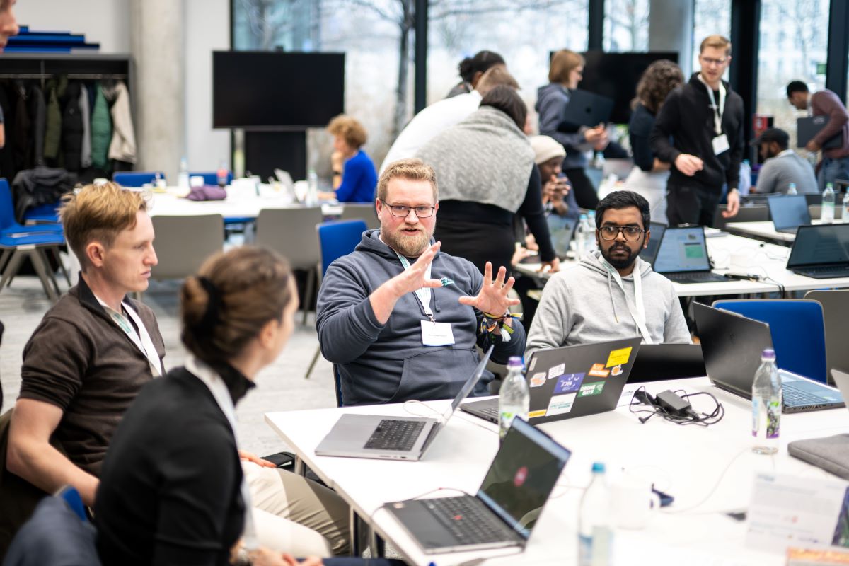 Menschen sitzen an einem Tisch und arbeiten. 