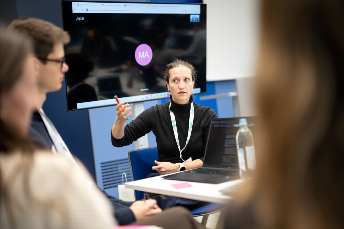  Eine Frau hält eine Präsentation vor einer Gruppe von Menschen.