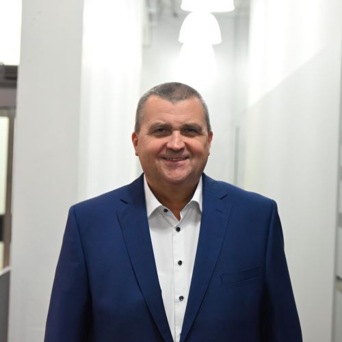 Auf dem Bild ist ein Herr in blauem Sakko und weißem Hemd zu sehen