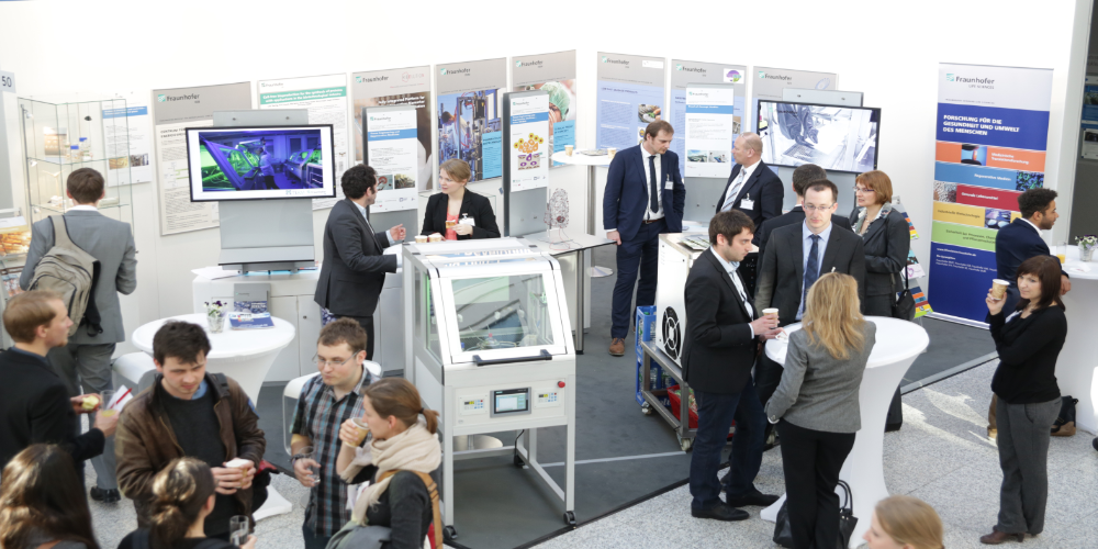 Menschen stehen an einem Messestand
