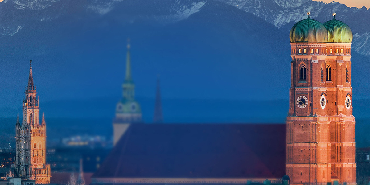 Mehrere Kirchen in einer Stadt vor einem Gebirge