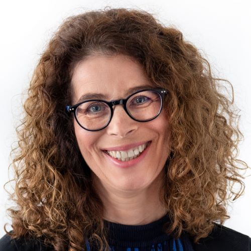auf dem Bild ist eine Dame mit Brille und Locken zu sehen