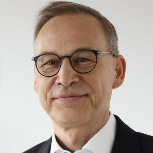 Auf dem Bild ist ein Herr mit Brille und Anzug zu sehen