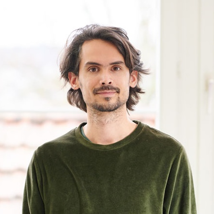 auf dem Bild ist ein Herr mit grünem Oberteil zu sehen