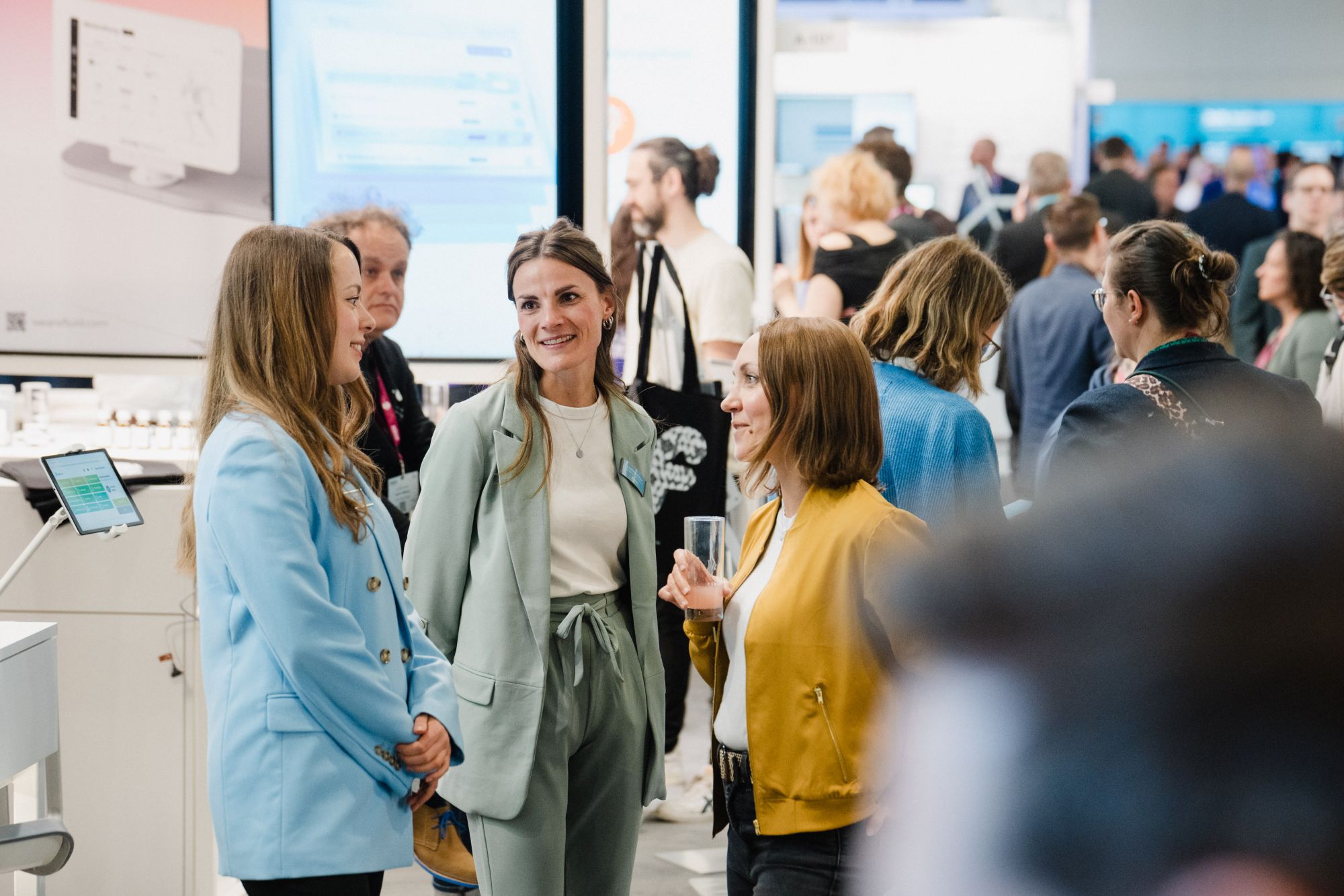 Gruppe von Menschen in einem hellen Ausstellungsraum mit Informationsdisplays im Hintergrund