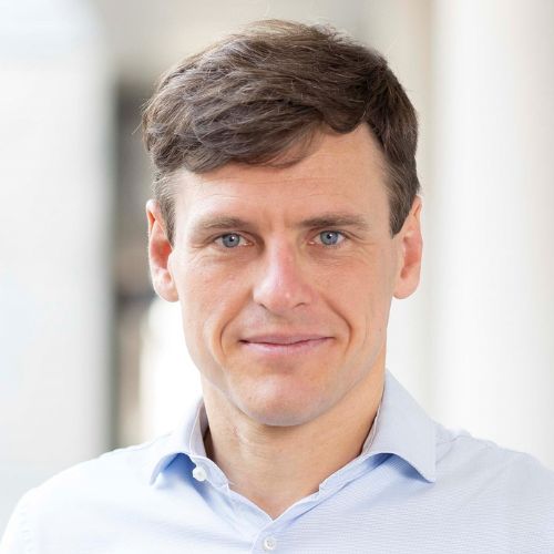 Mann mit braunen kurzen Haaren und hellblauen Hemd