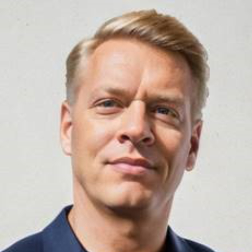 Portraitbild von Dr. Jörg Hetterich, einem blonden Mann in dunkelblauem Hemd