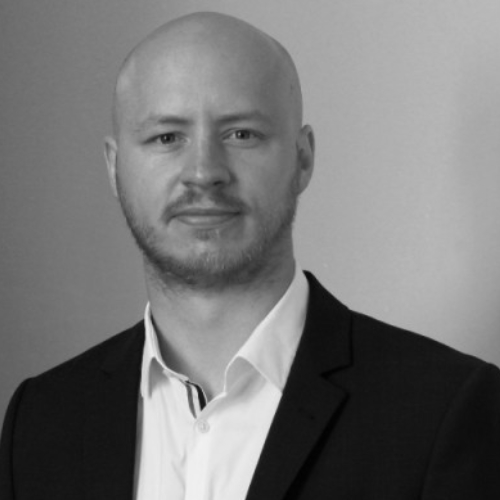 Mann mit Glatze, weißem Hemd und schwarzem Sakko