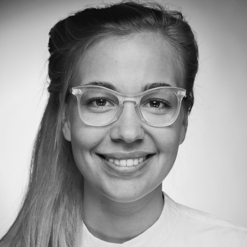 Porträt einer Frau mit langem, glattem Haar, das über die Schulter fällt, sie trägt ein helles Oberteil und blickt frontal in die Kamera