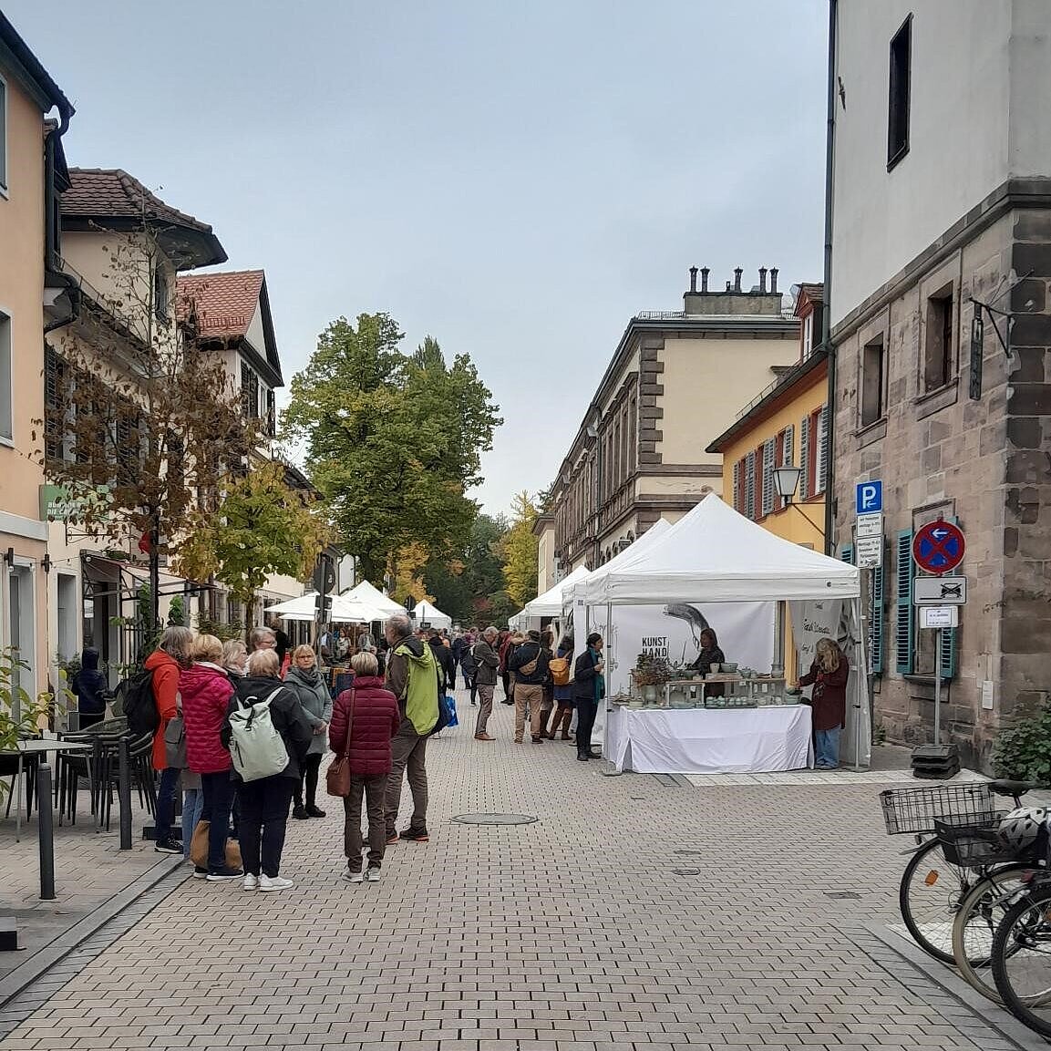 Bild auf eine Gasse mit Ständen und Menschen. 