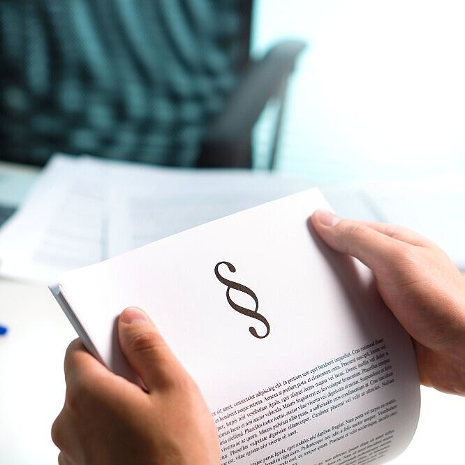 Mann hält ein juristisches Dokument in der Hand mit einem Abschnitt Zeichen nach Hause. Mann hält ein juristisches Dokument in der Hand. Anwalt hält Gesetz Papier im Büro
