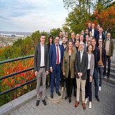Gruppenfoto im Freien mit Herbstbäumen im Hintergrund, mehrere Teilnehmende in formeller Kleidung. Aufgenommen bei der Delegationsreise in Kanada.