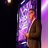 Dr. Rainer Seßner, Geschäftsführer, Bayern Innovativ GmbH, steht auf einer Bühne, während im Hintergrund das beleuchtete „TECH DAYS“-Logo zu sehen ist.